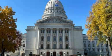 View of a grand capitol building with autumn trees.