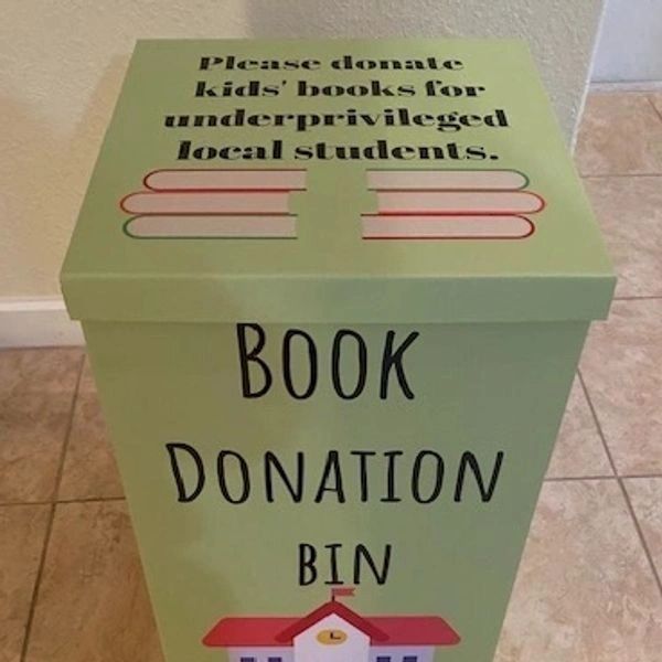 Green book donation bin for kids' books supporting underprivileged students.
