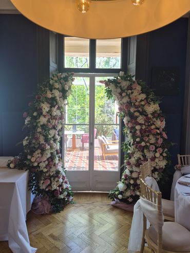 Floral arch decoration framing doorway at event venue.