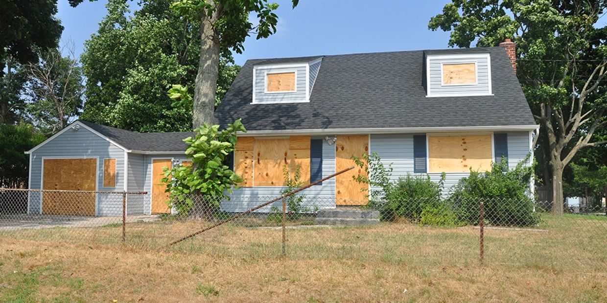 HUD home boarded up on first and second stories
