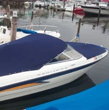 Blue Sunbrella ski boat cover with snap. Has support poles in center of Cockpit and Bow sections