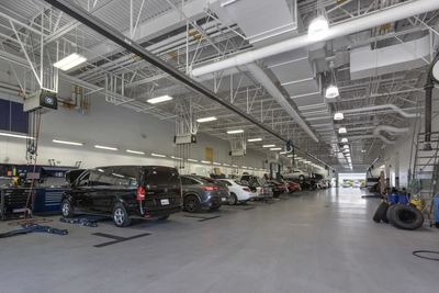 Spacious car service garage with multiple vehicles lined up for maintenance.
