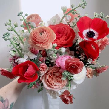 A vibrant bouquet with red, pink, and white flowers.