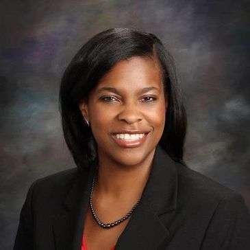 Professional portrait of a smiling woman in business attire.