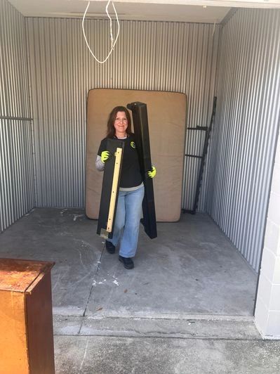 Nancy from Junk Zilla removing unwanted furniture during a storage unit cleanout in Bunnell, FL