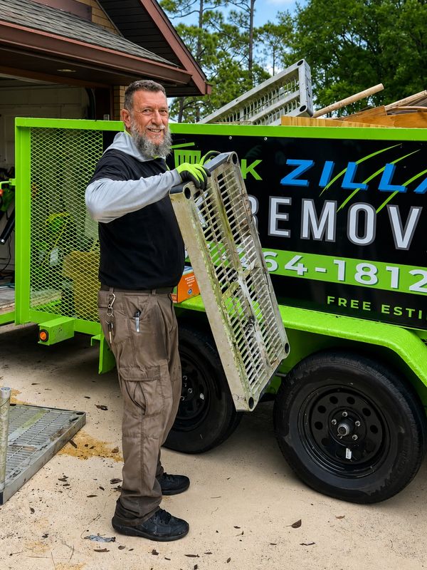 The owner of Junk Zilla loading the trailer during a garage and attic cleanout in New Smyrna Beach.