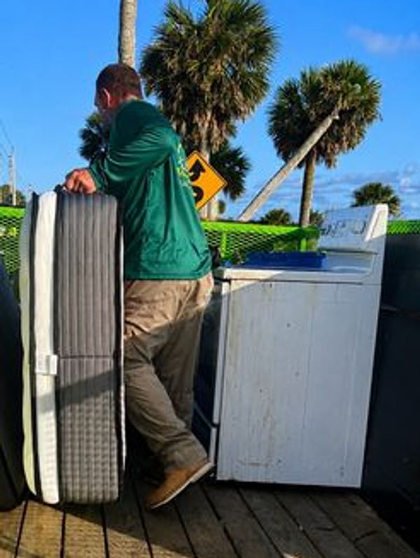 Tony loading a mattress on the Junk Zilla trailer from a Port Orange junk removal job.