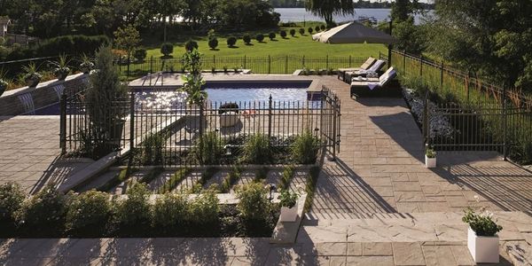 Une cours avec une piscine avec un grand terrain rempli de gazon et de cèdres au bord de l'eau