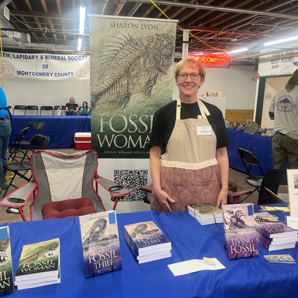 Author promoting fossil-themed books at a local mineral society event.