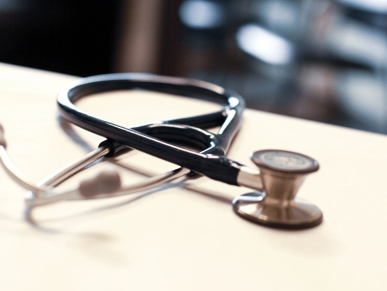 A stethoscope lies on a table, symbolizing medical care.