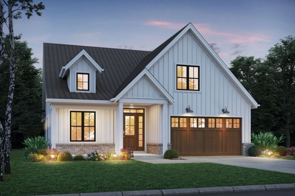 Modern farmhouse with white siding and dark roof at dusk.