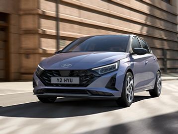 A sleek gray Hyundai hatchback driving on a city street.