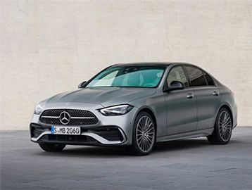 Sleek silver Mercedes-Benz sedan parked against a plain wall.