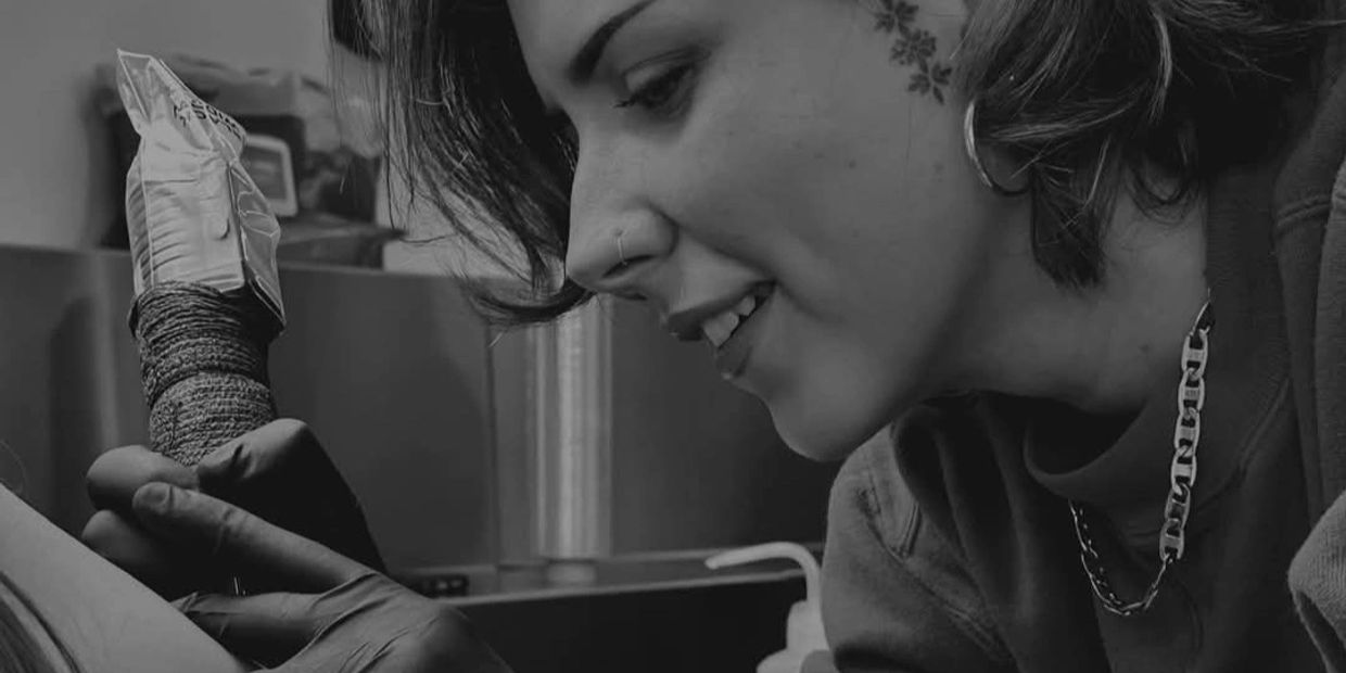 Tattoo artist concentrating while working on a client's tattoo.