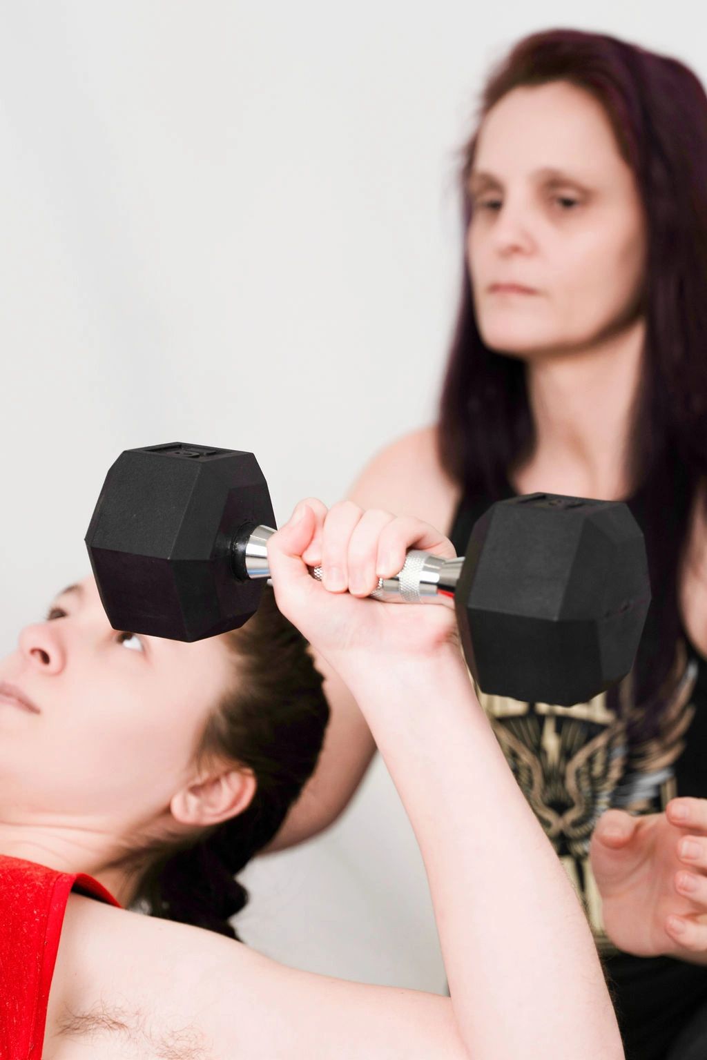 Denise from Step Forward Fitness providing a supportive spot during a dumbbell bench press.