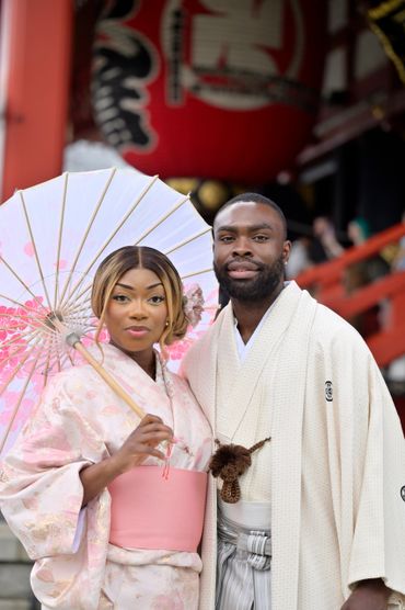 Couple dressed in traditional Japanese attire with a parasol.