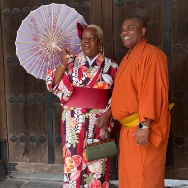 A couple dressed in traditional Japanese attire posing happily.