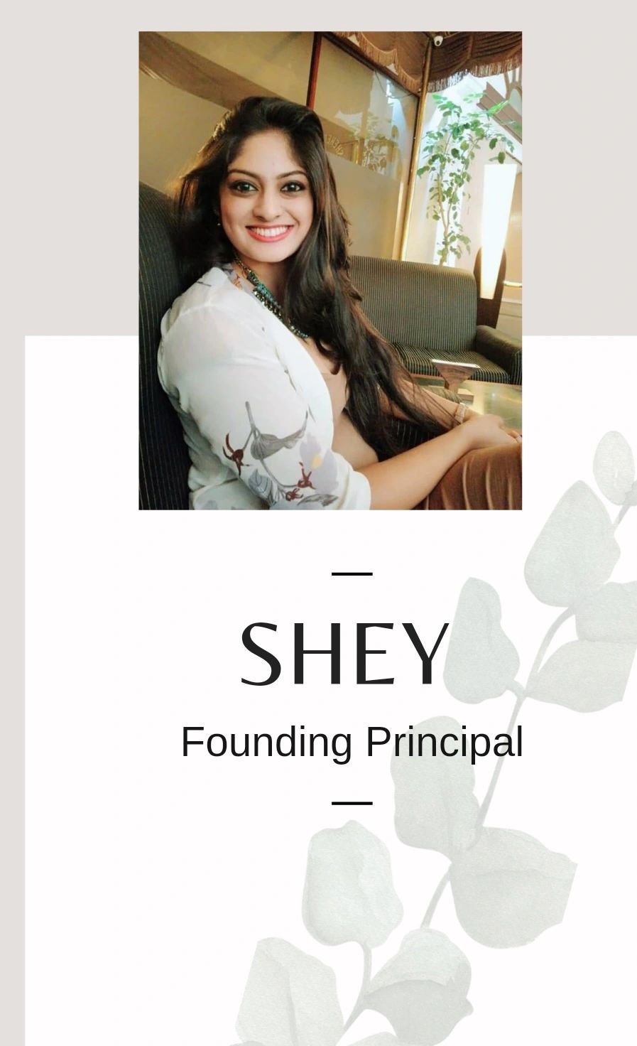Smiling woman seated on a couch with text 'SHEY Founding Principal'.