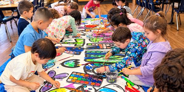 Children painting a large mural together.