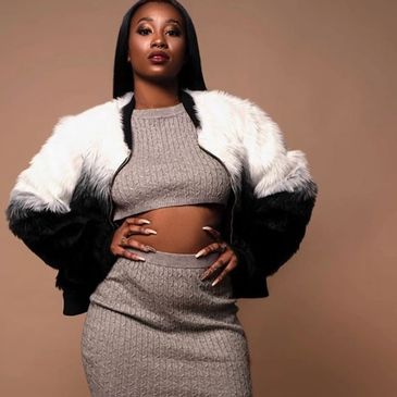 Confident woman in a stylish gray knit outfit and a black and white fur jacket.