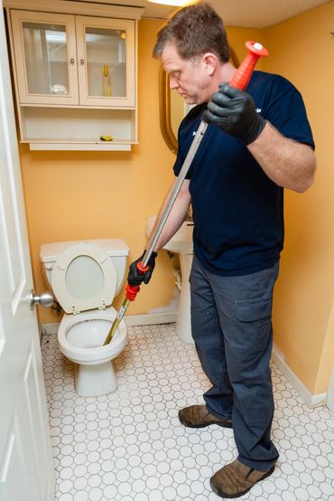a man cleanig the toilet drain 