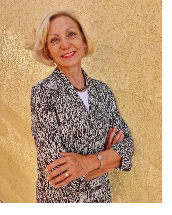 Amy Amundsen, Esq., a collaborative divorce attorney and mediator, leaning against a stucco wall.