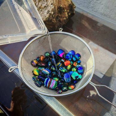 Rain water being poured onto glass in a sieve to clean it. 