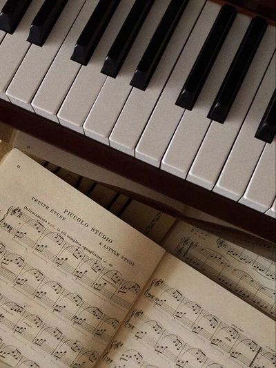 Close-up of piano keys with an open sheet music book showing musical notes.