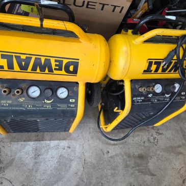 Two yellow DeWALT air compressors side by side.