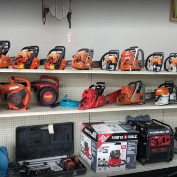 Shelves of chainsaws and power tools in a store.
