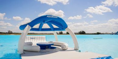 Inflatable floating lounge on a lake under blue sky.