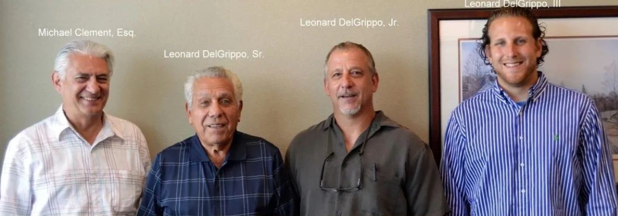 Four men standing together, smiling at the camera.