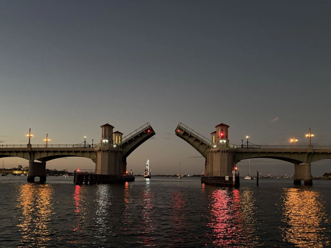 Drawbridge raised at dusk with reflections on water.