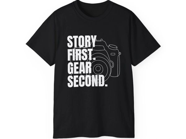 Black t-shirt with camera graphic and text about storytelling and gear.