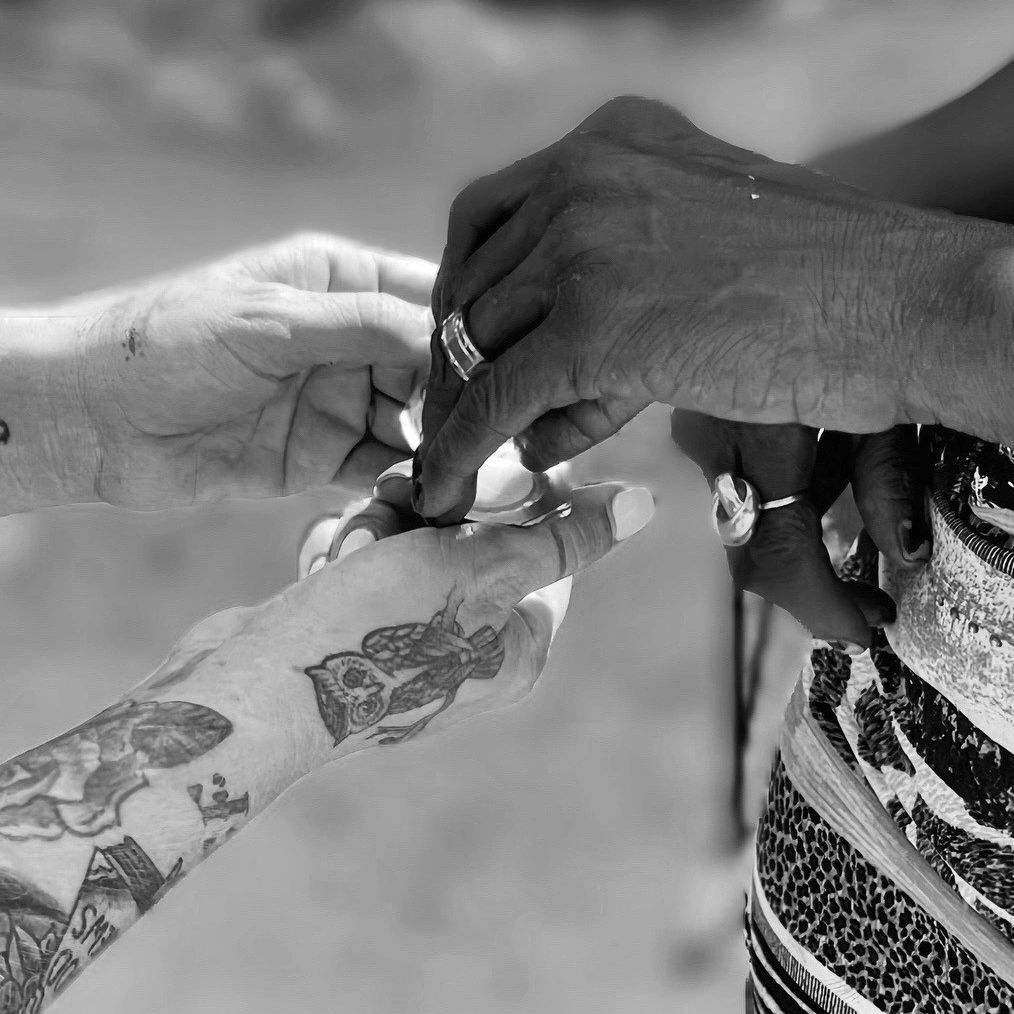 Two people exchanging rings, showcasing diversity and connection.