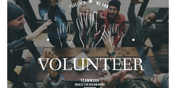 Group of diverse volunteers joining hands in teamwork and unity.