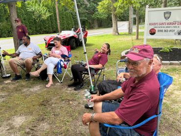 Group of adults relaxing outdoors in chairs.
