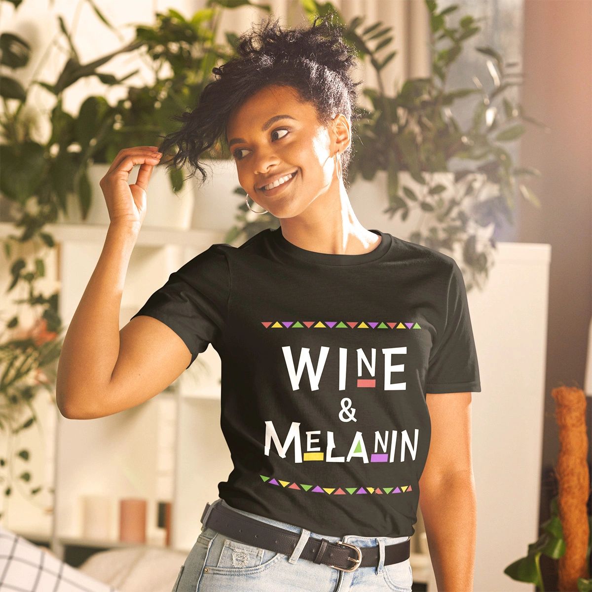 Black woman posing with a black t-shirt that says Wine & Melanin 