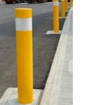 Yellow and white bollards along a sidewalk curb.