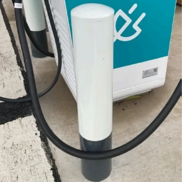 Electric vehicle charging station with a protective bollard.