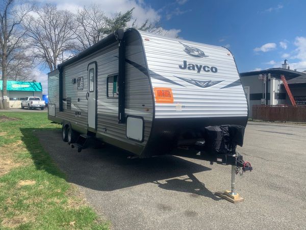 Jayco travel trailer parked on a driveway on a sunny day.