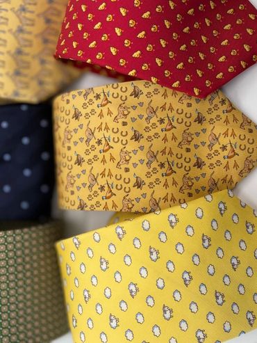 Colorful neckties with various playful patterns including animals, clouds, and geometric shapes.