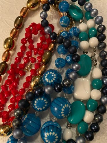 Colorful beaded necklaces with various shapes and patterns.