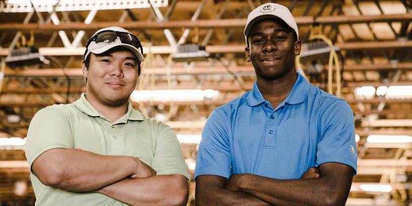 Two men standing confidently with arms crossed indoors.