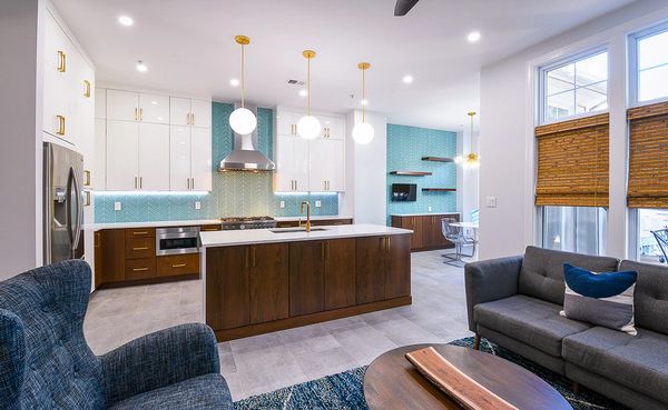Modern kitchen and living area with teal accents and wooden finishes.