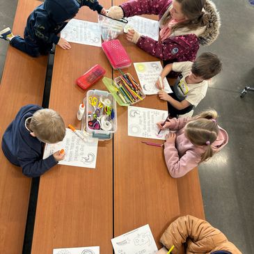 Children coloring and doing activities at a table with supplies.