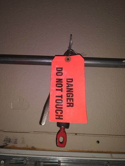 Red danger tag on a lever saying 'DO NOT TOUCH'.