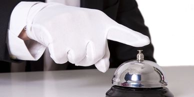 White gloved hand touching service bell. Hospitality training. Hotel consulting. Management consulti