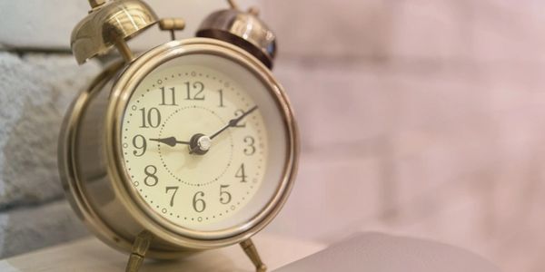 Old fashioned golden alarm clock. Time for hotel opening