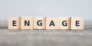 Wooden blocks on the table reading ENGAGE. Hospitality consulting. Hotel Consulting. Training 